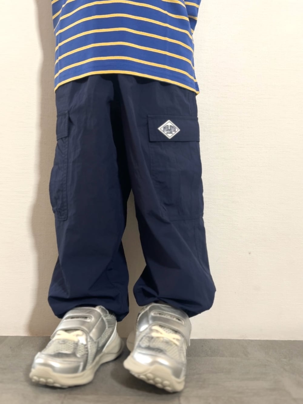 ブルー系のTシャツ/カットソー、ブルー系のその他パンツ、シルバー系のスニーカーを着用したキッズの秋コーディネートの5枚目の写真