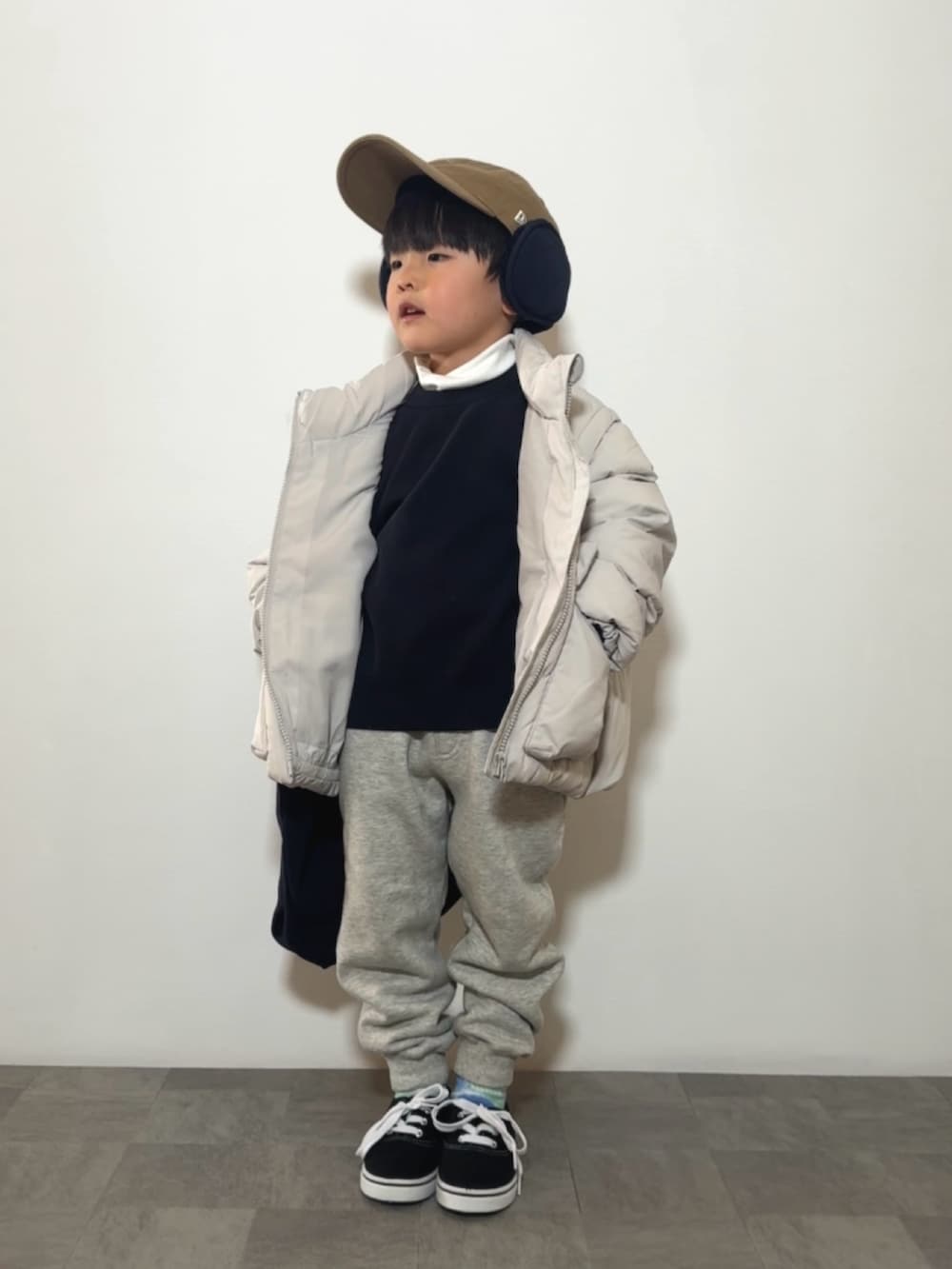 ブラック系のスニーカー、ホワイト系のTシャツ/カットソー、ブルー系のニット/セーターを着用したキッズの冬コーディネートの2枚目の写真