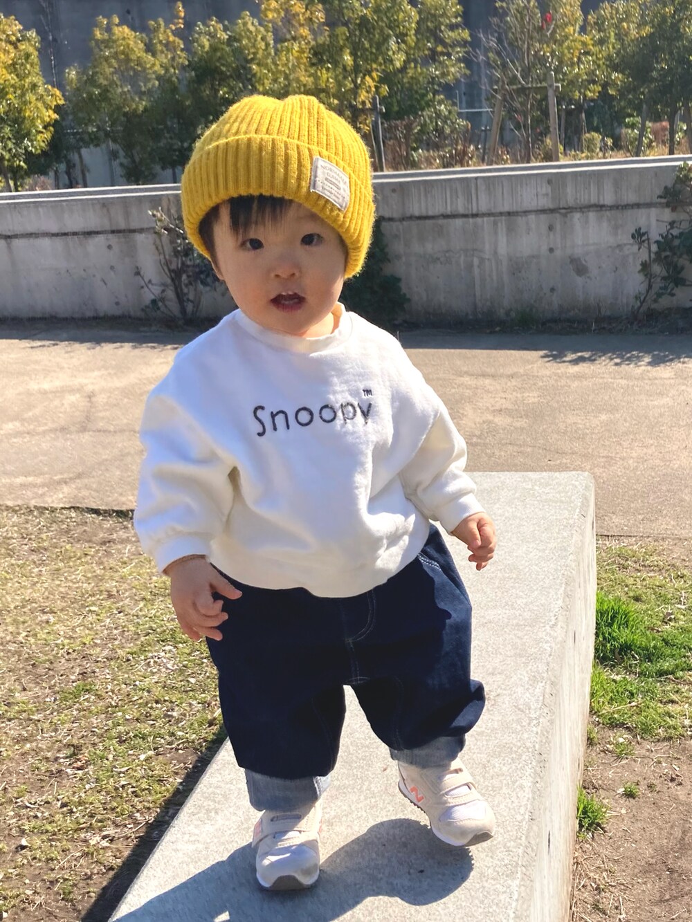 グリーン系のダウンジャケット/コート、ホワイト系のスウェット、ブルー系のデニムパンツを着用したキッズの冬コーディネートの2枚目の写真