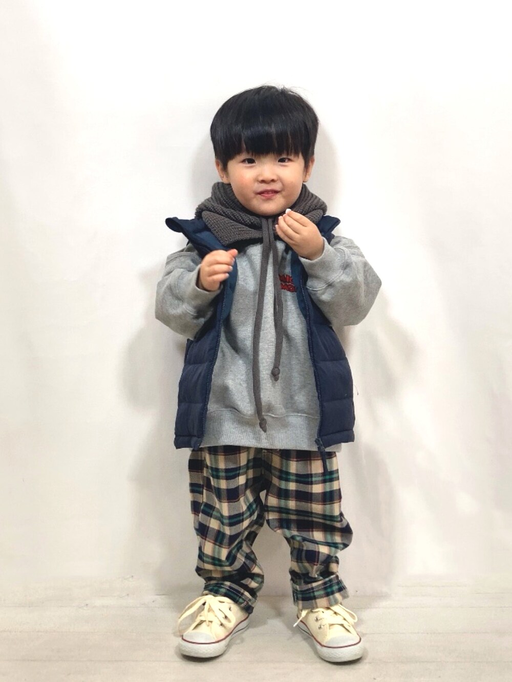 グレー系のスウェット、ブルー系のダウンベスト、ブルー系のその他パンツを着用したキッズの秋コーディネートの2枚目の写真