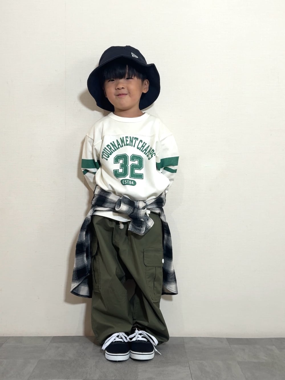 ブラック系のスニーカー、グリーン系のカーゴパンツ、ホワイト系のトップスを着用したキッズの夏コーディネートの3枚目の写真