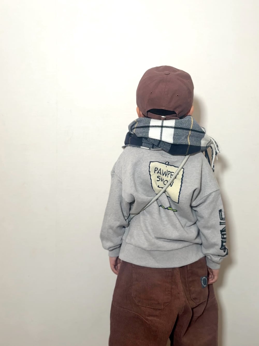 ブラウン系のその他パンツ、ブラウン系のローファー、グレー系のショルダーバッグを着用したキッズの冬コーディネートの4枚目の写真