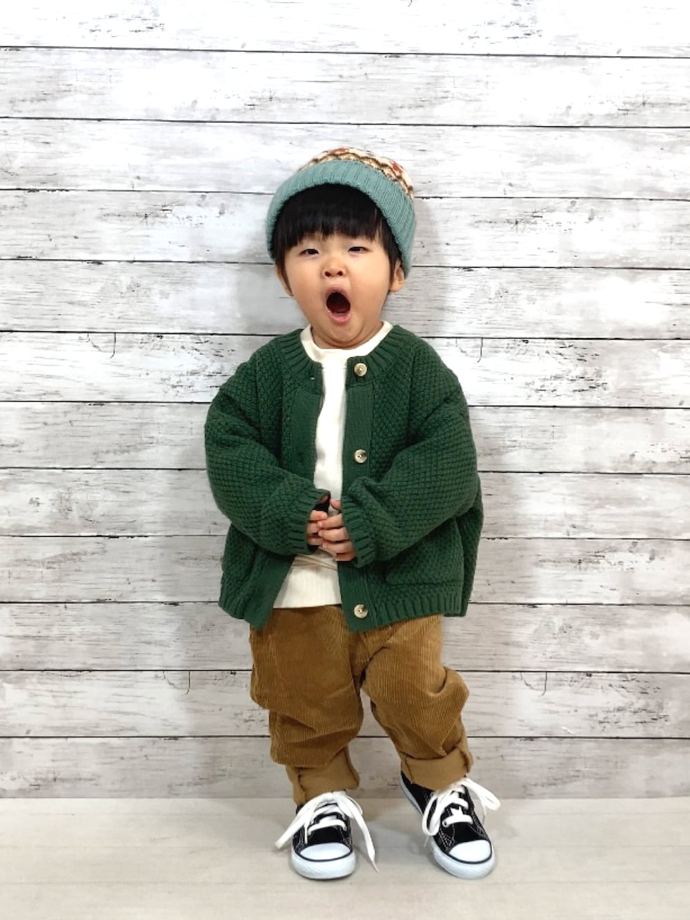 グリーン系のカーディガン/ボレロ、ホワイト系のスウェット、イエロー系のその他パンツを着用したキッズの秋コーディネートの2枚目の写真