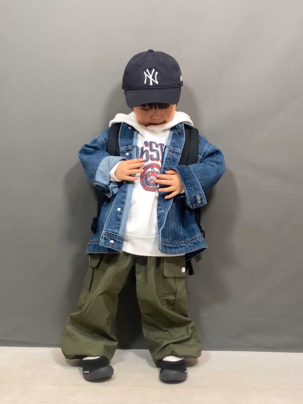 ブルー系のデニムジャケット、ホワイト系のスウェット、グリーン系のカーゴパンツを着用したキッズの冬コーディネートの5枚目の写真