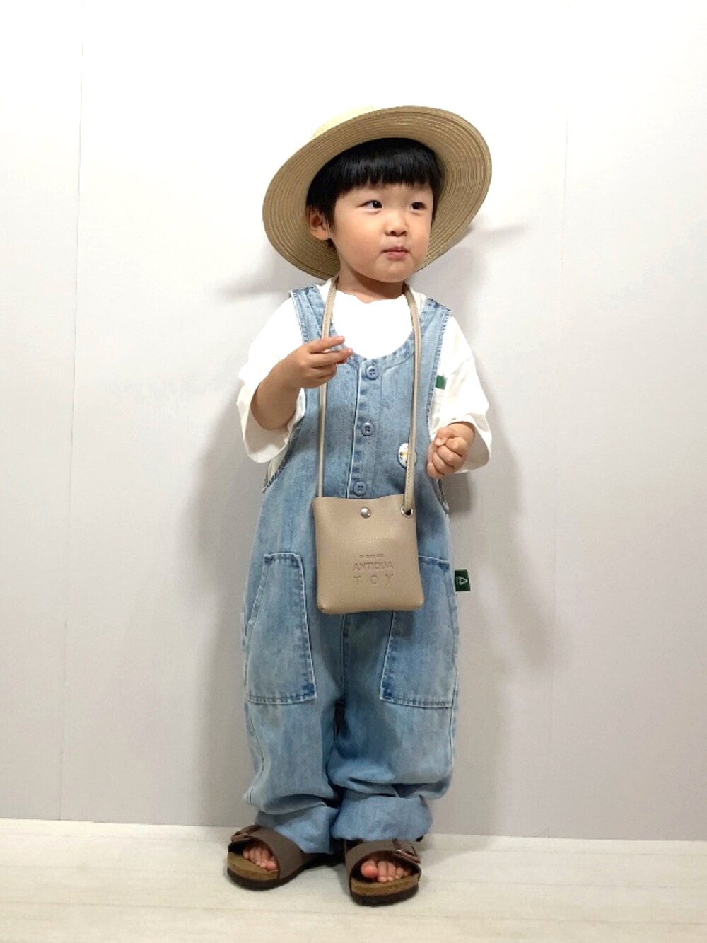 ホワイト系のTシャツ/カットソー、ブルー系のサロペット/オーバーオール、ベージュ系のショルダーバッグを着用したキッズの夏コーディネートの2枚目の写真