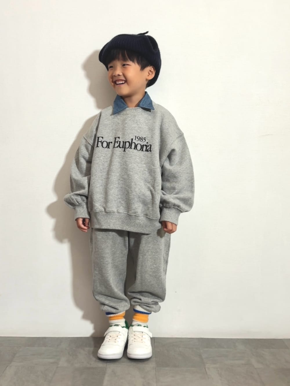 グレー系のスウェット、グレー系のスウェットパンツ、ホワイト系のスニーカーを着用したキッズの秋コーディネートの2枚目の写真