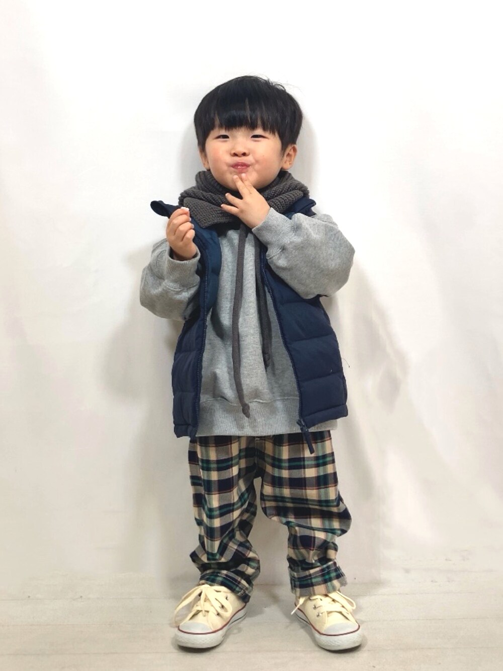 グレー系のスウェット、ブルー系のダウンベスト、ブルー系のその他パンツを着用したキッズの秋コーディネートの3枚目の写真