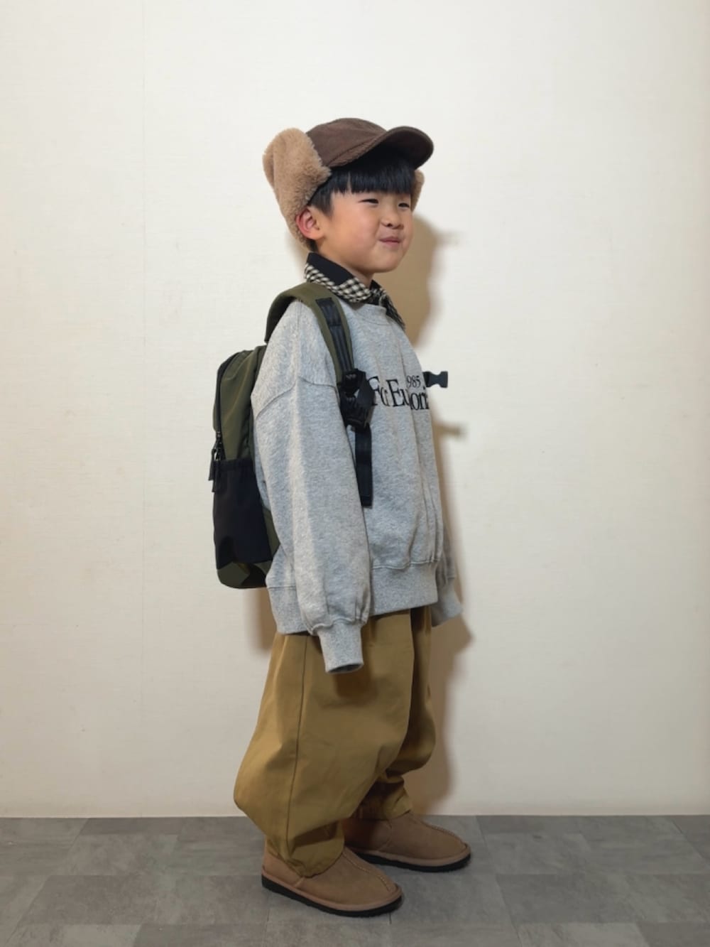 グレー系のスウェット、ブラウン系のその他パンツ、イエロー系のブーツを着用したキッズの冬コーディネートの3枚目の写真