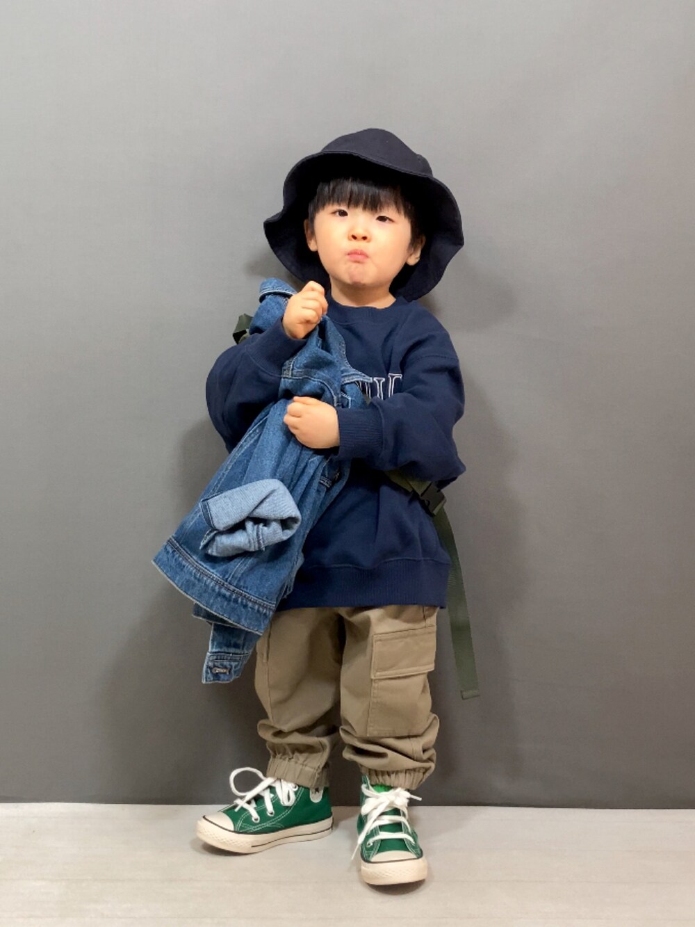 ブルー系のデニムジャケット、ブルー系のスウェット、ベージュ系のパンツを着用したキッズの冬コーディネートの5枚目の写真