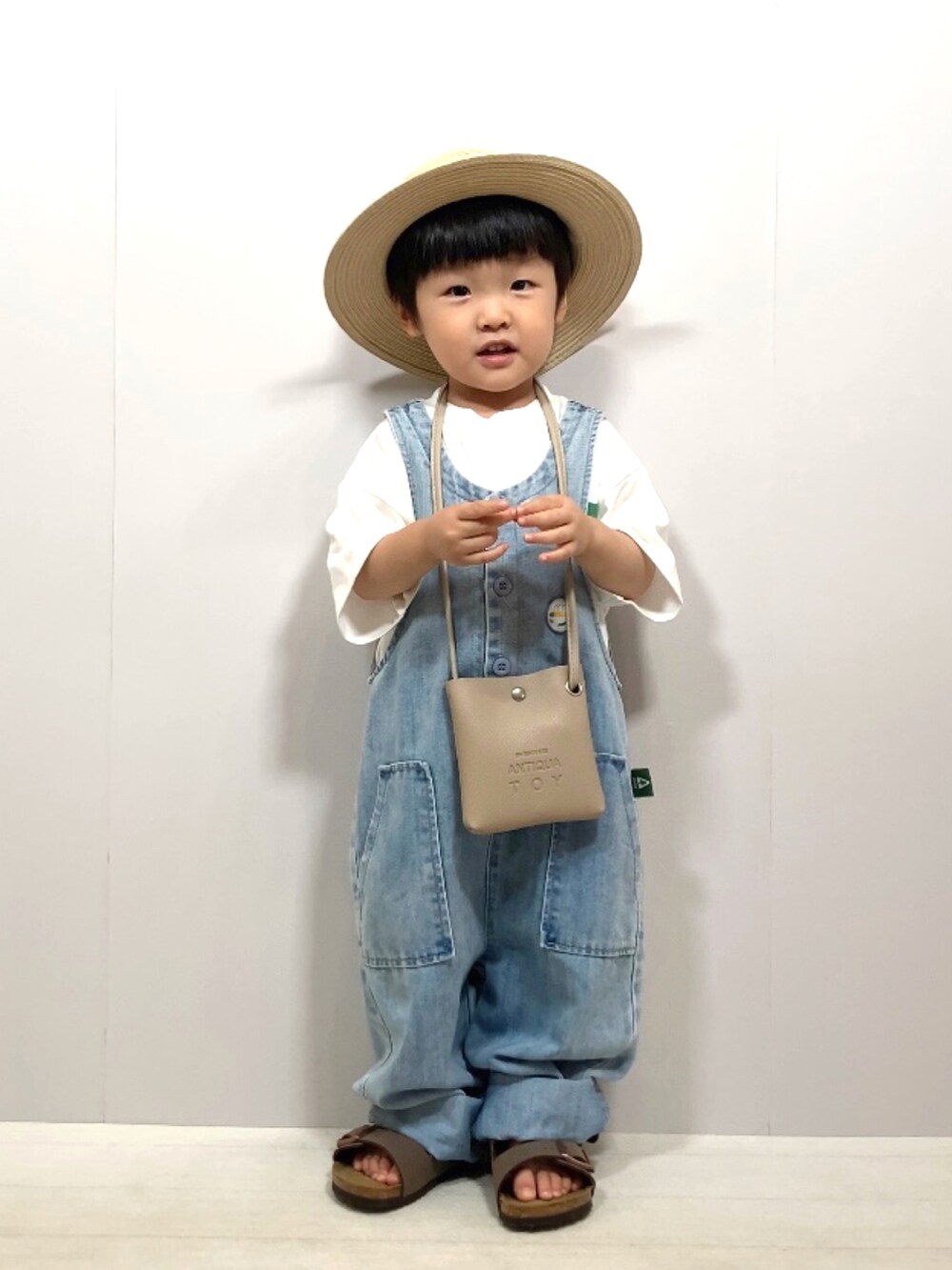 ホワイト系のTシャツ/カットソー、ブルー系のサロペット/オーバーオール、ベージュ系のショルダーバッグを着用したキッズの夏コーディネートの4枚目の写真