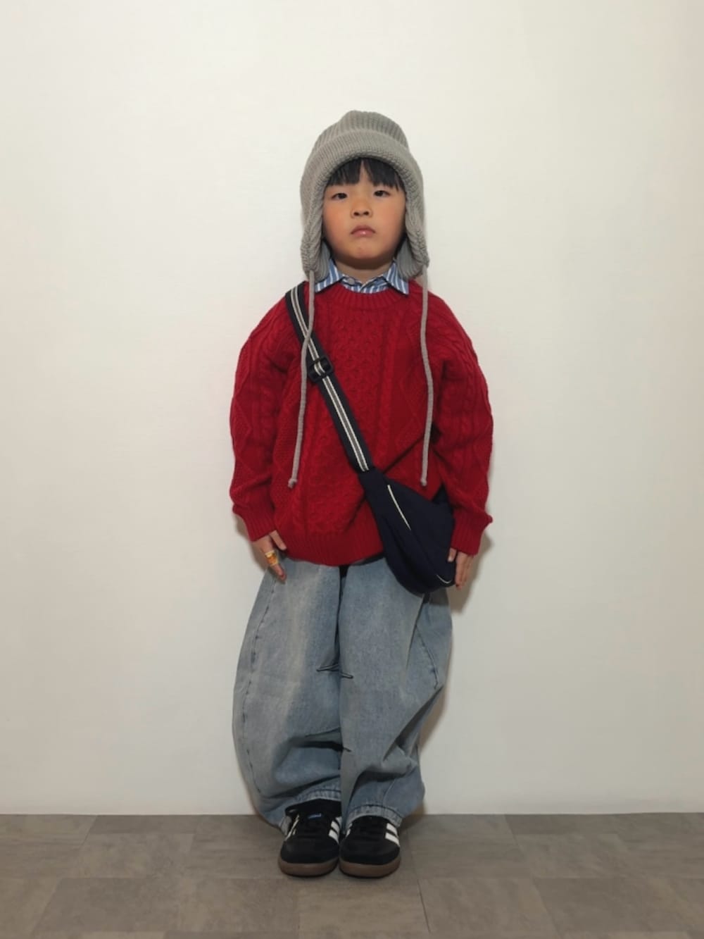 ブルー系のシャツ/ブラウス、レッド系のニット/セーター、ブラック系のスニーカーを着用したキッズの冬コーディネートの3枚目の写真