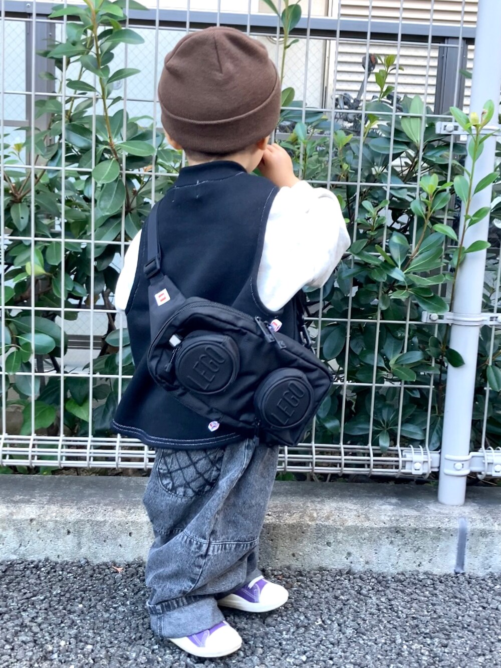 ブラック系のベスト、グレー系のスウェット、ブラック系のデニムパンツを着用したキッズの秋コーディネートの4枚目の写真