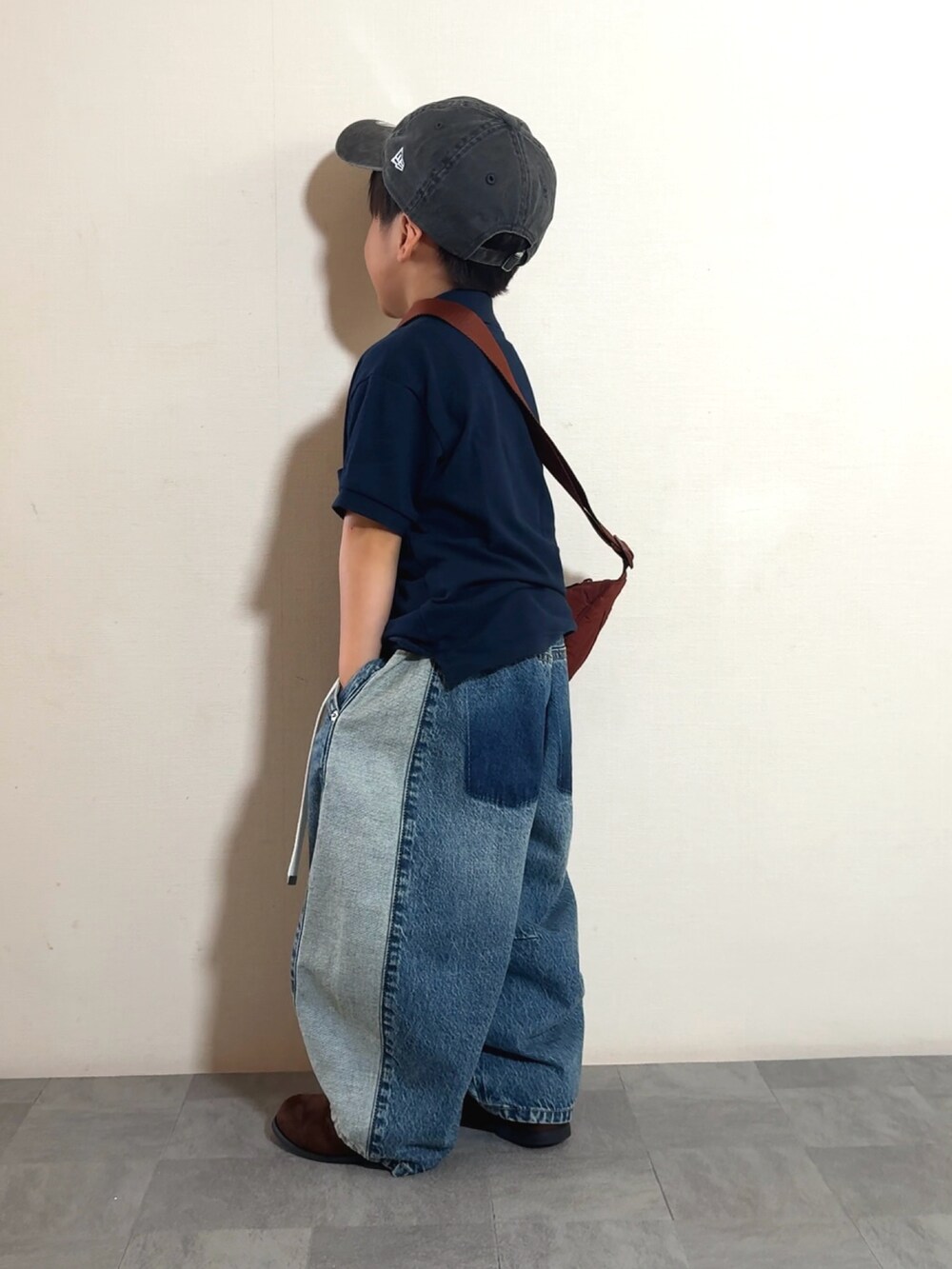 ブルー系のデニムパンツ、ブラウン系のブーツ、ブルー系のポロシャツを着用したキッズの夏コーディネートの4枚目の写真