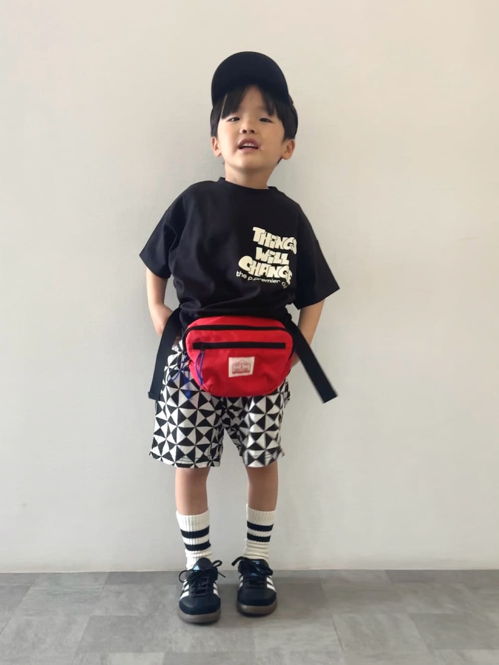 ブラック系のスニーカー、ブラック系のTシャツ/カットソー、レッド系のボディバッグ/ウエストポーチを着用したキッズの春コーディネートの3枚目の写真