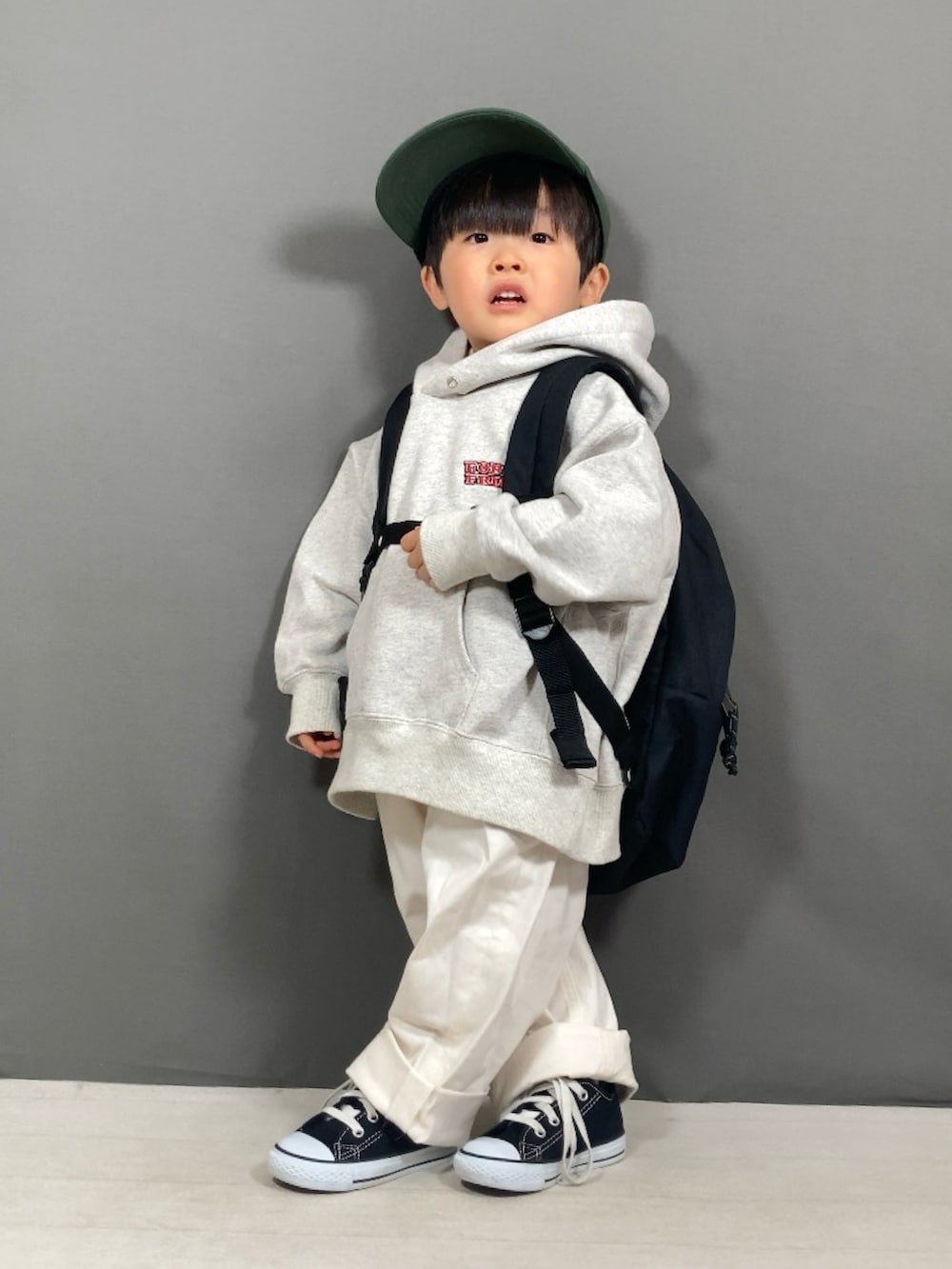 グレー系のスウェット、ホワイト系のパンツ、ブラック系のバックパック/リュックを着用したキッズの春コーディネートの3枚目の写真