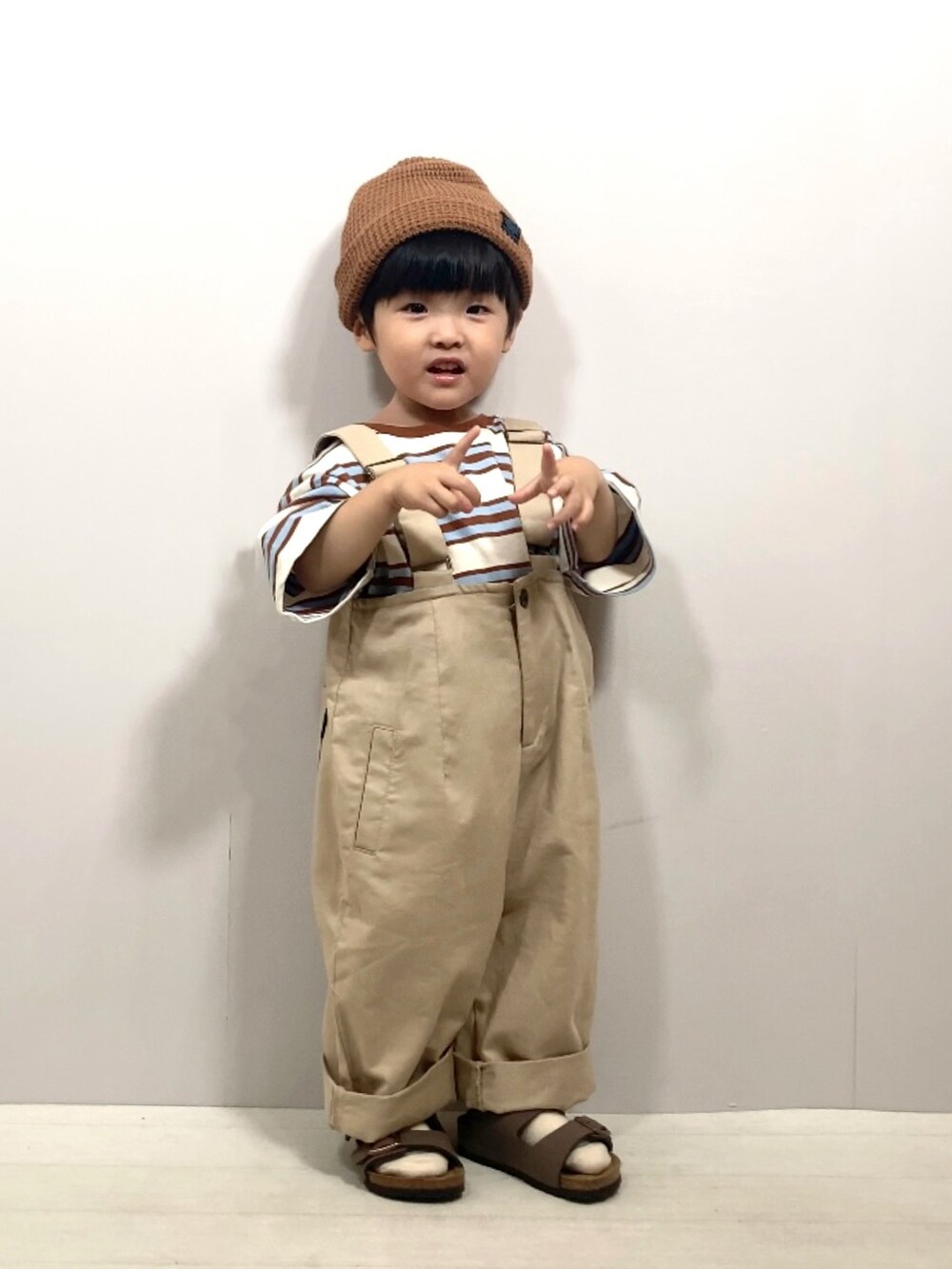 ベージュ系のTシャツ/カットソー、ベージュ系のサロペット/オーバーオール、ブラウン系のサンダルを着用したキッズの夏コーディネートの5枚目の写真
