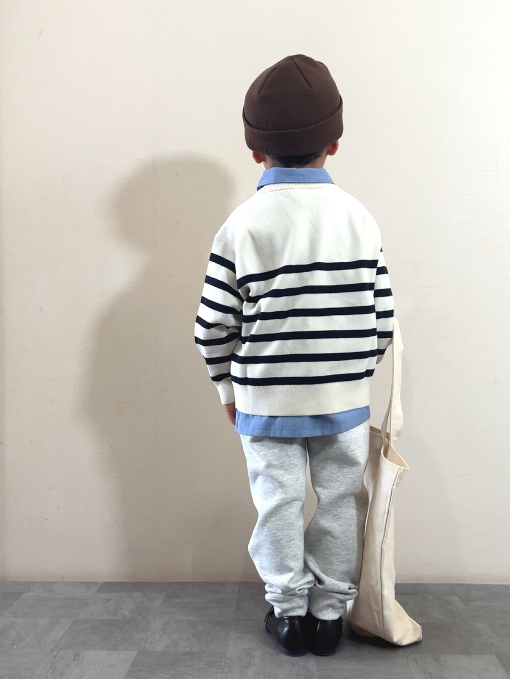 ブラウン系のローファー、ブルー系のシャツ/ブラウス、ホワイト系のニット/セーターを着用したキッズの秋コーディネートの2枚目の写真