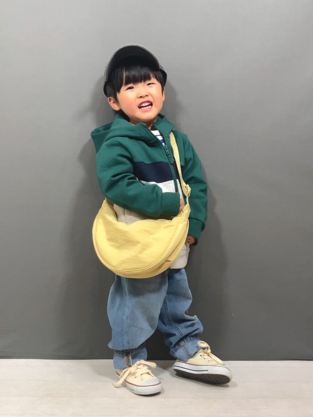 グリーン系のパーカー、ブルー系のTシャツ/カットソー、ブルー系のデニムパンツを着用したキッズの冬コーディネートの3枚目の写真