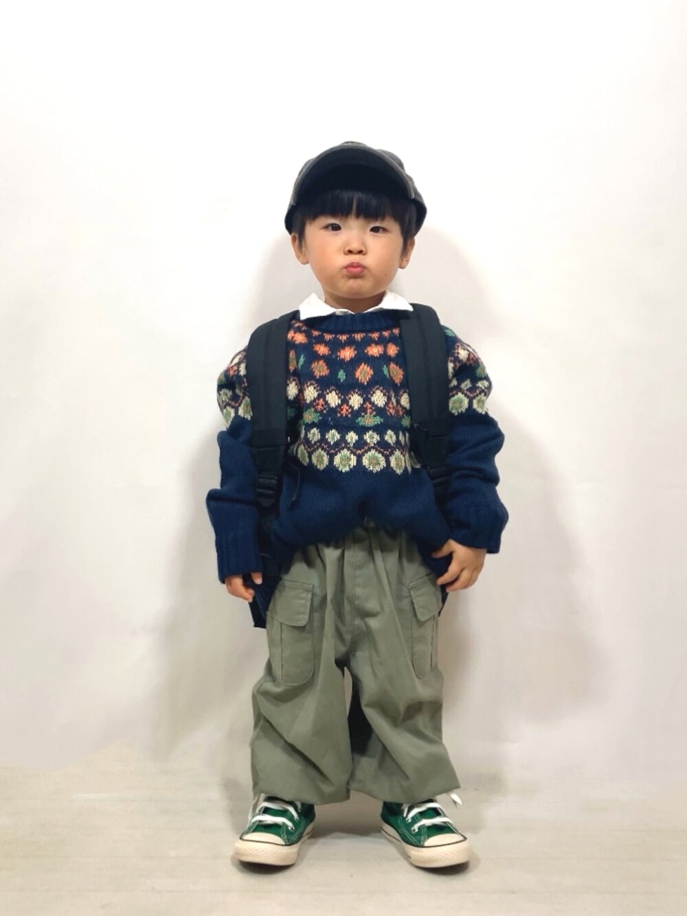 ブルー系のニット/セーター、ホワイト系のシャツ/ブラウス、グリーン系のカーゴパンツを着用したキッズの冬コーディネートの5枚目の写真