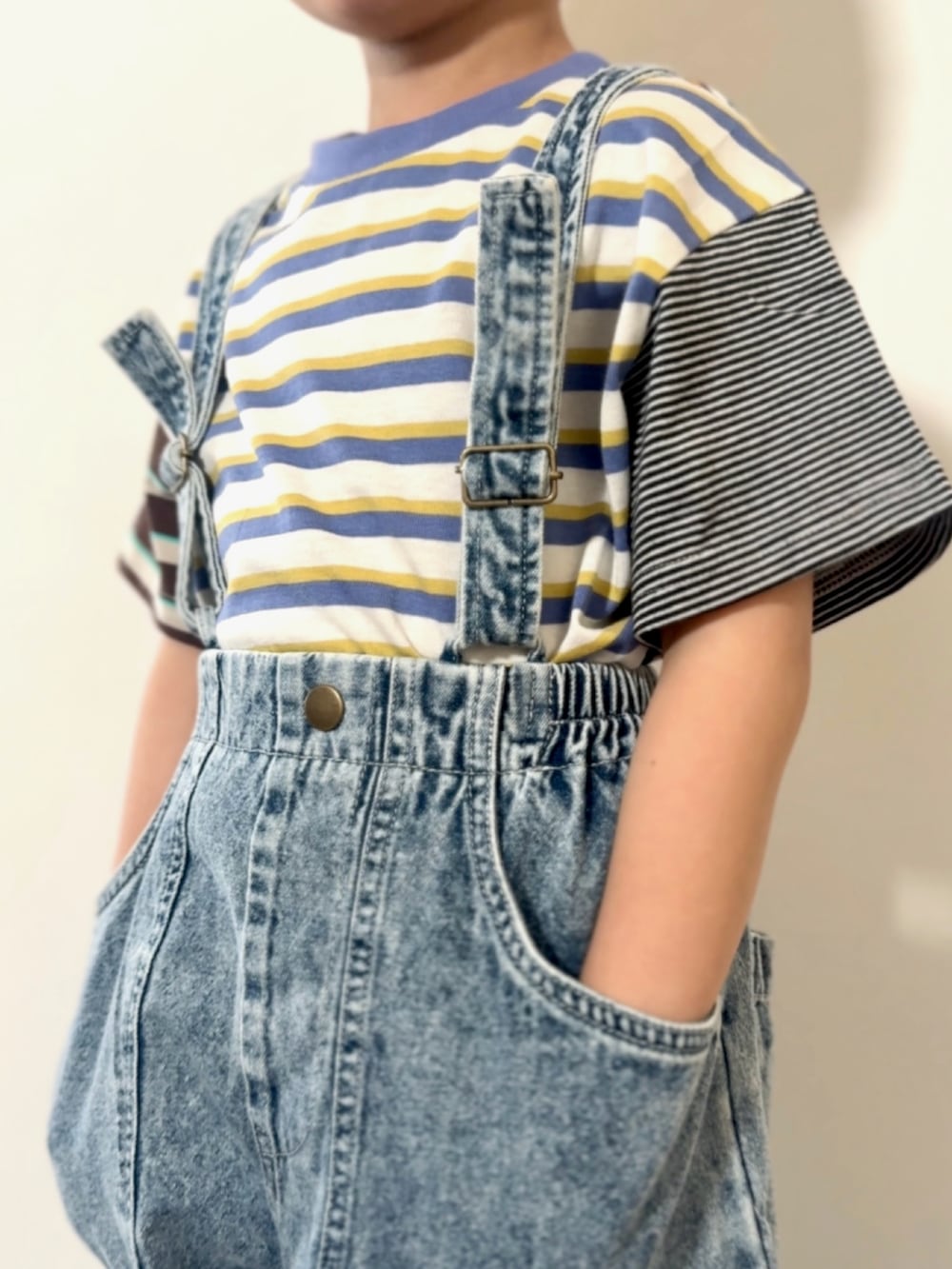 シルバー系のスニーカー、その他のTシャツ/カットソー、ブルー系のデニムパンツを着用したキッズの春コーディネートの3枚目の写真