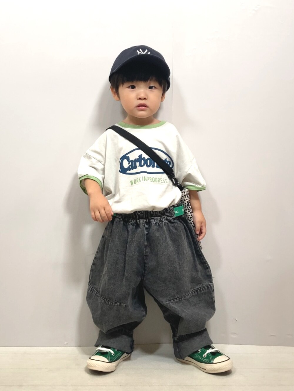 グレー系のTシャツ/カットソー、ブラック系のデニムパンツ、ベージュ系のショルダーバッグを着用したキッズの夏コーディネートの3枚目の写真