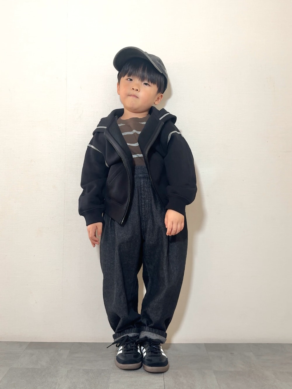 ブラック系のサロペット/オーバーオール、ブラック系のスニーカー、ブラウン系のTシャツ/カットソーを着用したキッズの秋コーディネートの2枚目の写真