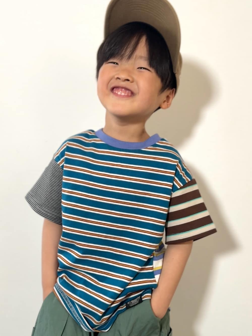 グレー系のショルダーバッグ、ブラック系のスニーカー、その他のTシャツ/カットソーを着用したキッズの春コーディネートの3枚目の写真