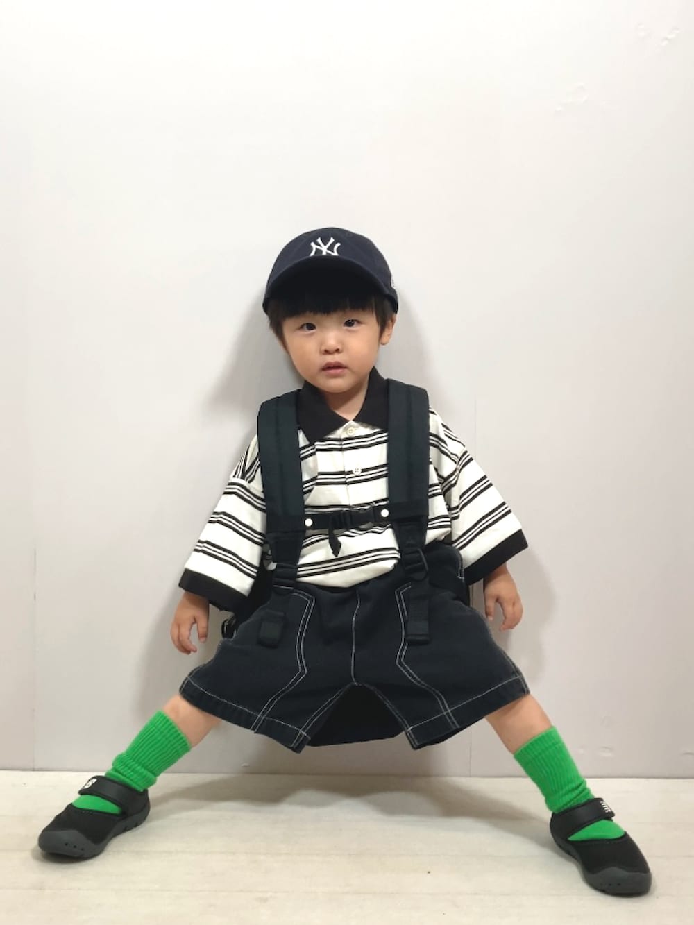 ベージュ系のポロシャツ、ブラック系のその他パンツ、ブラック系のバックパック/リュックを着用したキッズの夏コーディネートの5枚目の写真