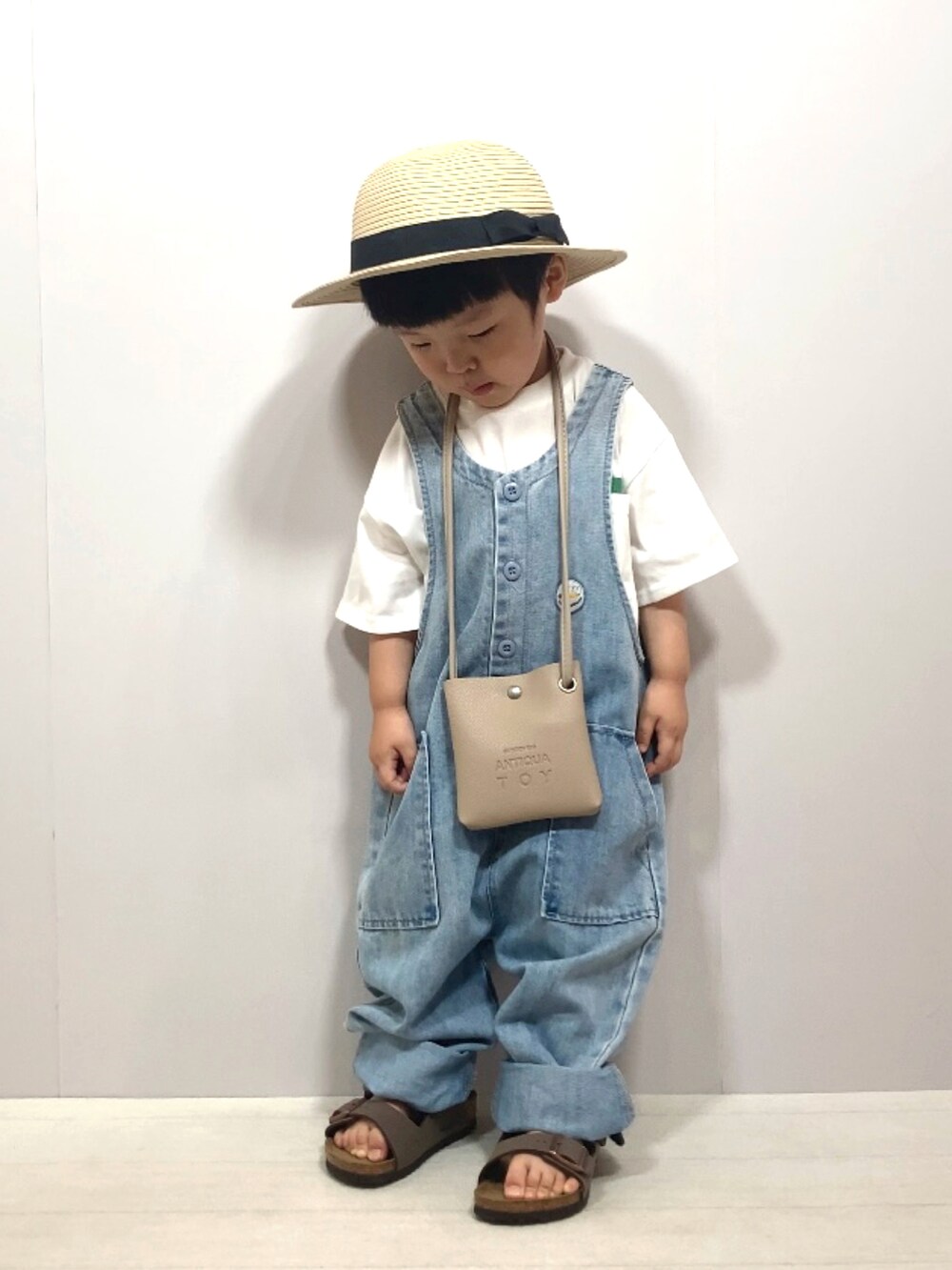 ホワイト系のTシャツ/カットソー、ブルー系のサロペット/オーバーオール、ベージュ系のショルダーバッグを着用したキッズの夏コーディネートの5枚目の写真