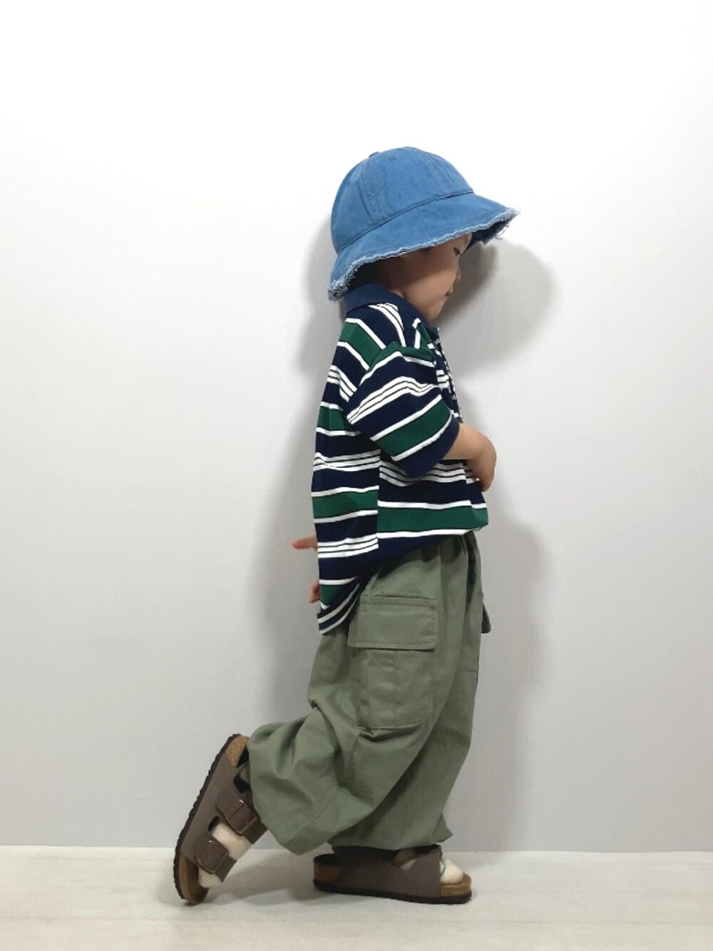 ブルー系のポロシャツ、グリーン系のカーゴパンツ、ブラウン系のサンダルを着用したキッズの夏コーディネートの5枚目の写真