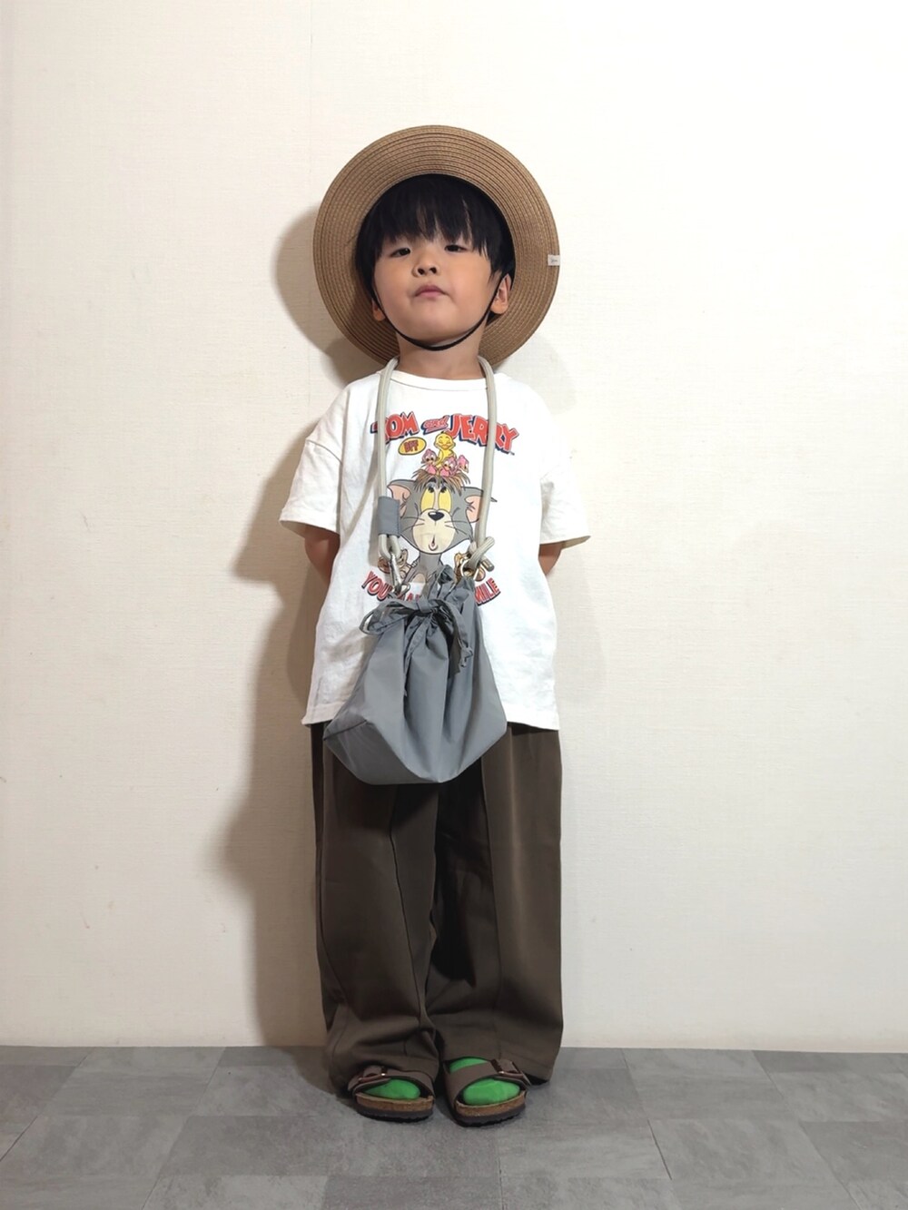 ホワイト系のTシャツ/カットソー、グレー系のショルダーバッグ、ブラウン系のスラックスを着用したキッズの夏コーディネートの3枚目の写真