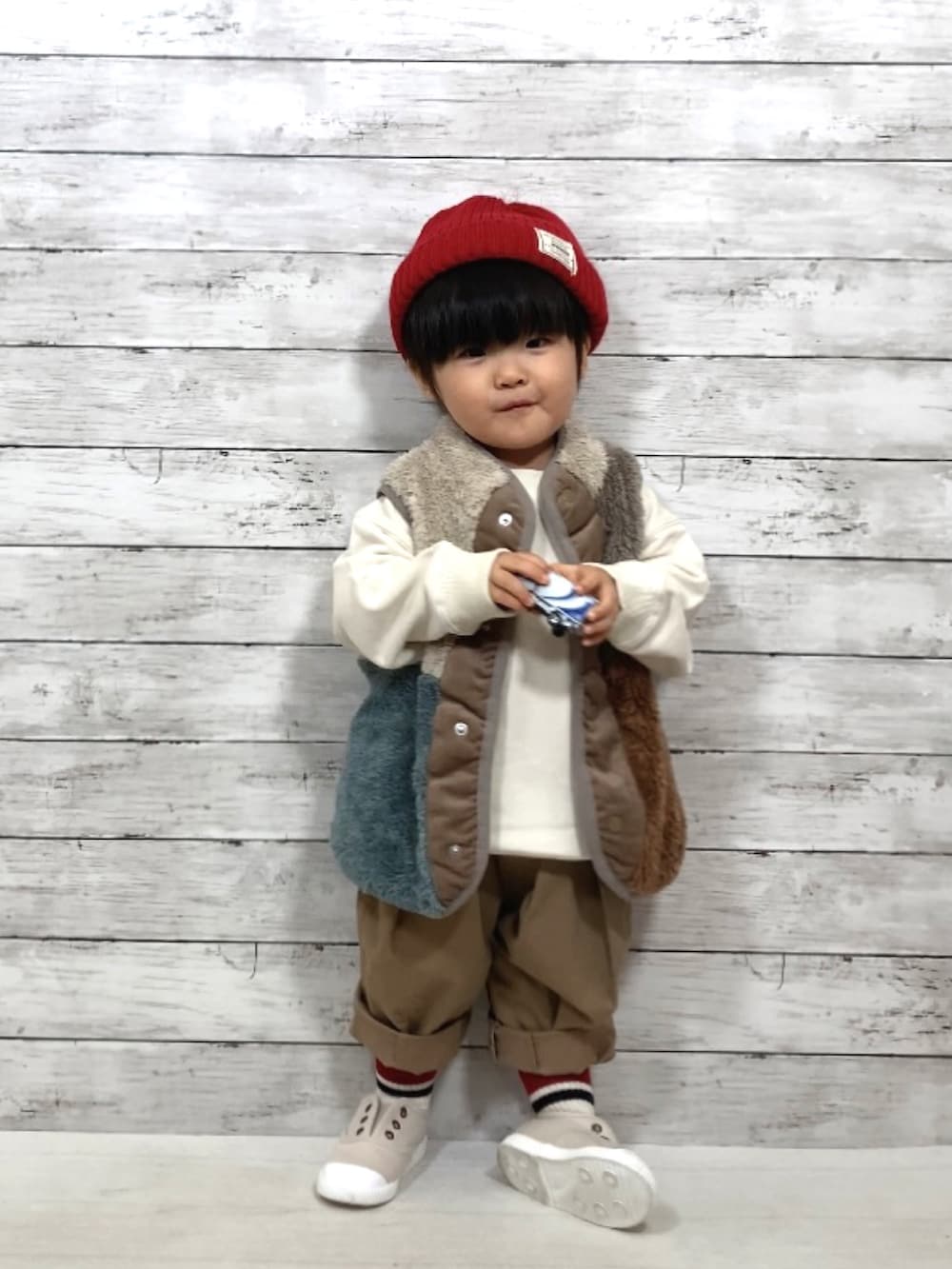 その他のベスト、ホワイト系のスウェット、ベージュ系のその他パンツを着用したキッズの秋コーディネートの2枚目の写真