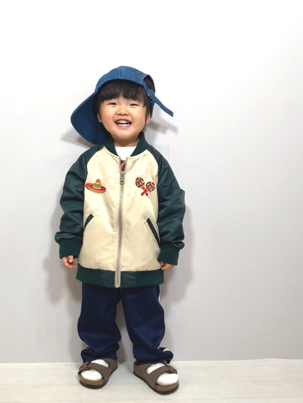 グリーン系のブルゾン、ホワイト系のTシャツ/カットソー、ブルー系のその他パンツを着用したキッズの春コーディネートの3枚目の写真