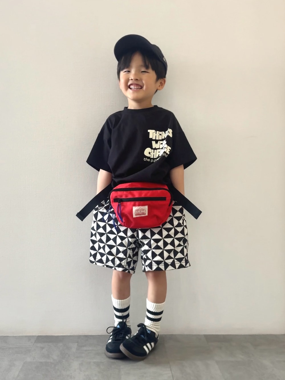 ブラック系のスニーカー、ブラック系のTシャツ/カットソー、レッド系のボディバッグ/ウエストポーチを着用したキッズの春コーディネートの2枚目の写真