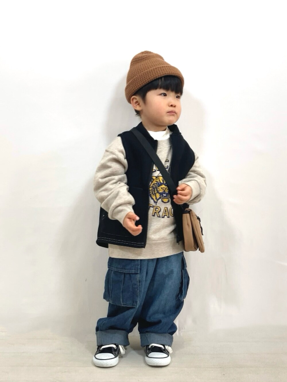 ブラック系のベスト、ホワイト系のスウェット、ホワイト系のTシャツ/カットソーを着用したキッズの冬コーディネートの5枚目の写真