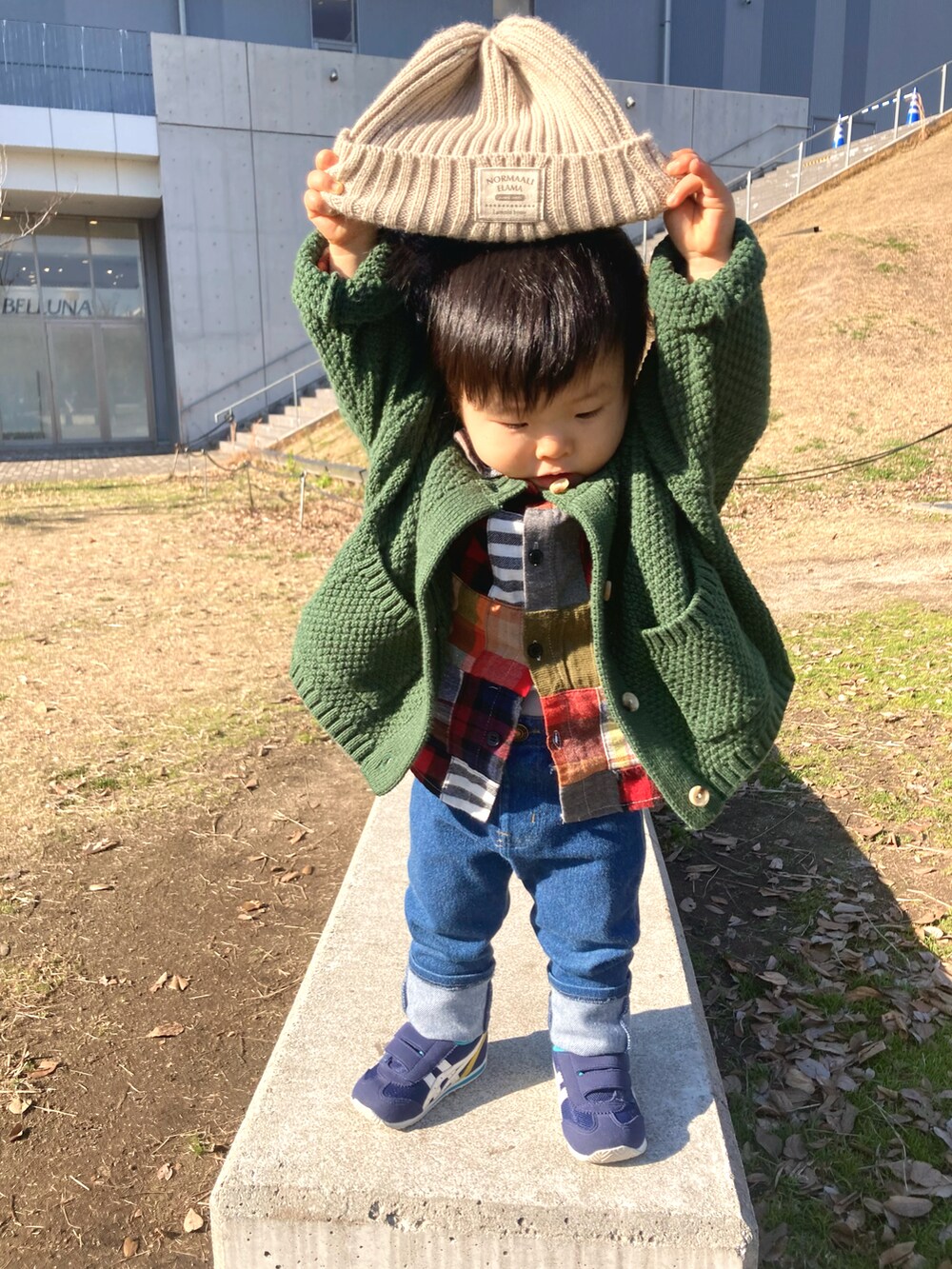 レッド系のシャツ/ブラウス、ブルー系のデニムパンツ、グリーン系のカーディガン/ボレロを着用したキッズの冬コーディネートの2枚目の写真