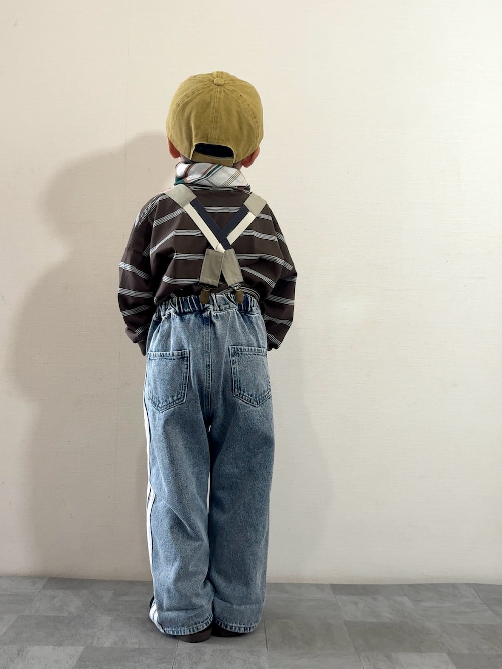 ブルー系のデニムパンツ、ブラック系のスニーカー、ブラウン系のTシャツ/カットソーを着用したキッズの秋コーディネートの4枚目の写真