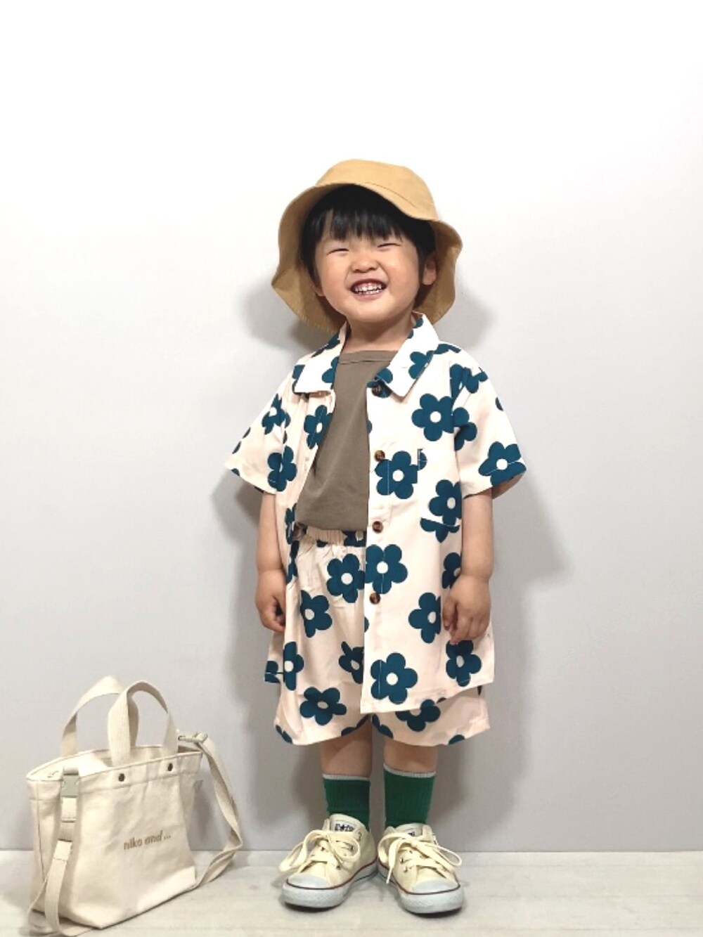 ベージュ系のセットアップ、グリーン系のTシャツ/カットソー、ホワイト系のスニーカーを着用したキッズの春コーディネートの4枚目の写真