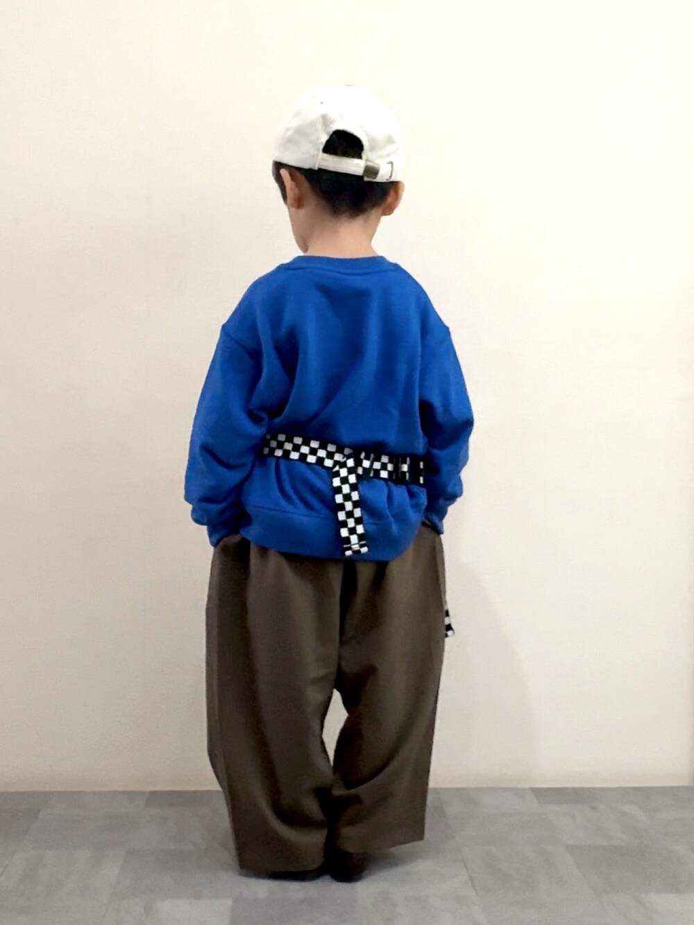 ブラウン系のスラックス、ブラウン系のローファー、ブルー系のスウェットを着用したキッズの秋コーディネートの4枚目の写真
