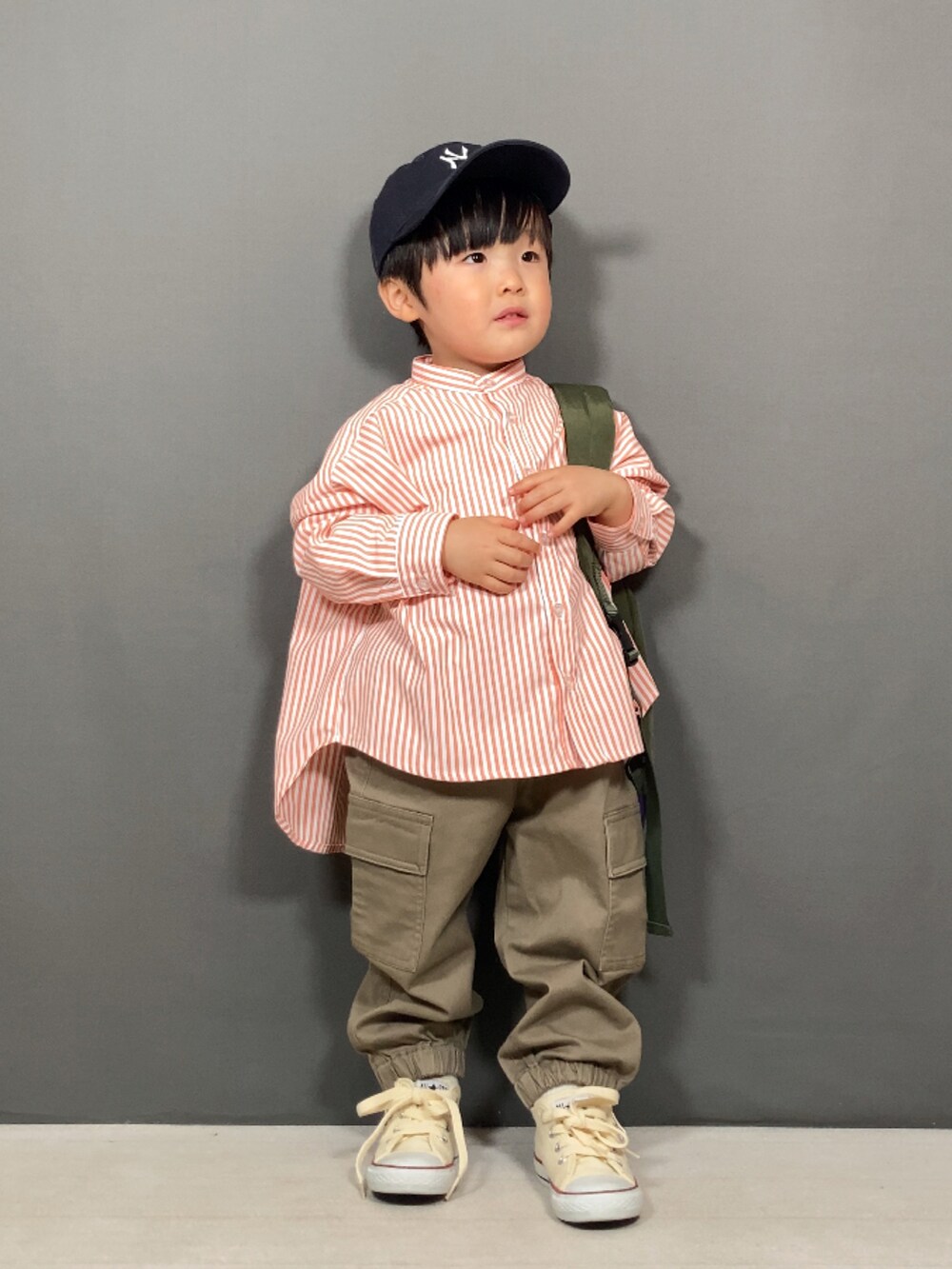 オレンジ系のシャツ/ブラウス、ブラック系のパンツ、グリーン系のボディバッグ/ウエストポーチを着用したキッズの春コーディネートの2枚目の写真