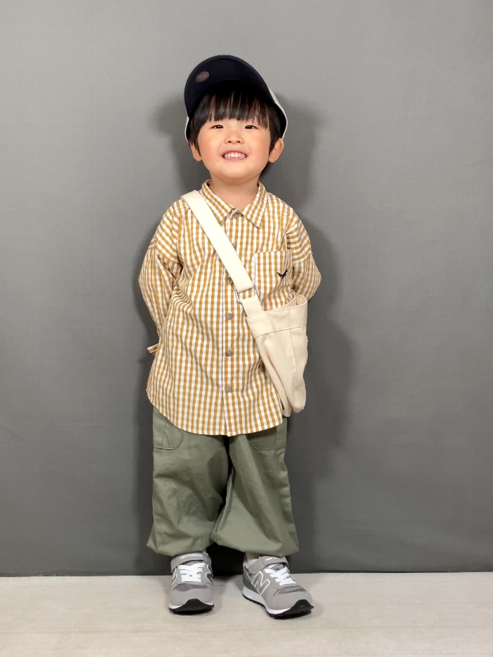 イエロー系のシャツ/ブラウス、グリーン系のカーゴパンツ、ホワイト系のショルダーバッグを着用したキッズの春コーディネートの3枚目の写真