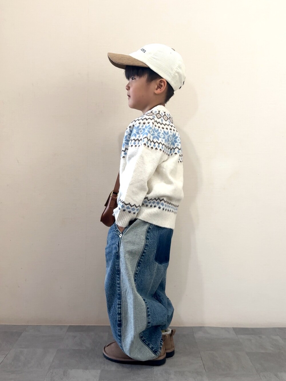 ブルー系のデニムパンツ、イエロー系のブーツ、ホワイト系のニット/セーターを着用したキッズの秋コーディネートの3枚目の写真