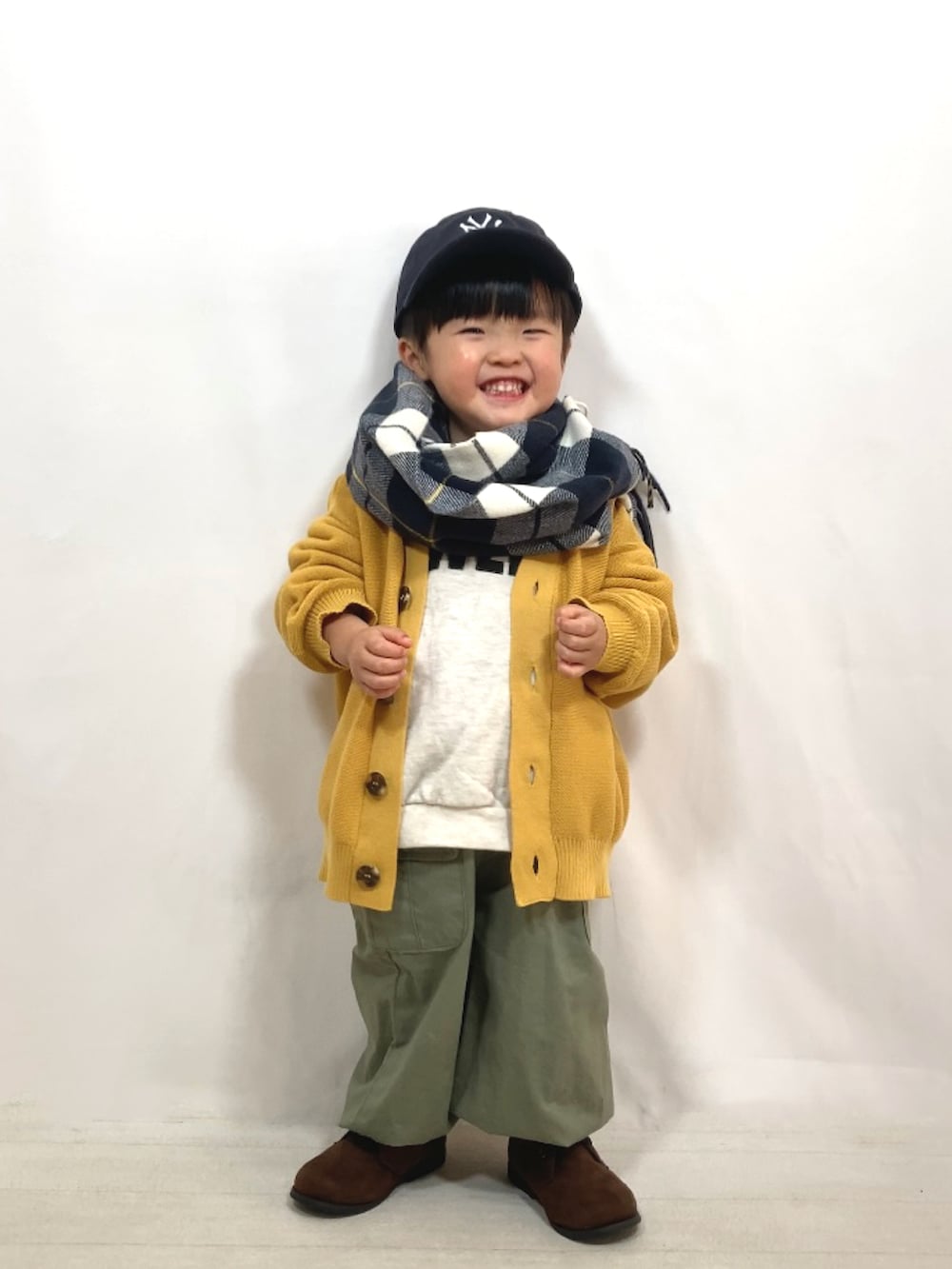 イエロー系のカーディガン/ボレロ、グレー系のスウェット、グリーン系のカーゴパンツを着用したキッズの秋コーディネートの2枚目の写真