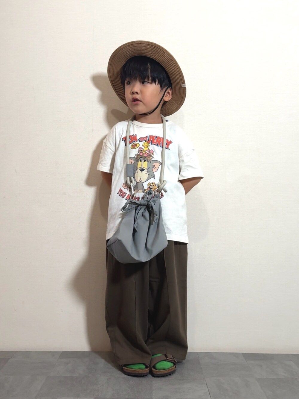 ホワイト系のTシャツ/カットソー、グレー系のショルダーバッグ、ブラウン系のスラックスを着用したキッズの夏コーディネートの2枚目の写真
