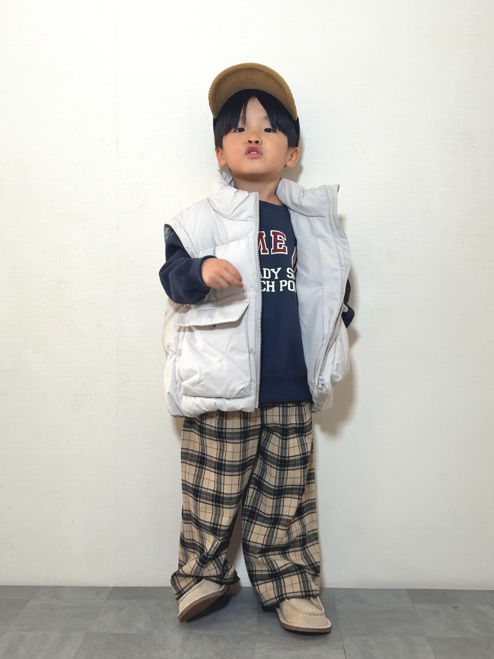 ベージュ系のモカシン/デッキシューズ、ブルー系のスウェット、ホワイト系のジャケット/アウターを着用したキッズの冬コーディネートの2枚目の写真