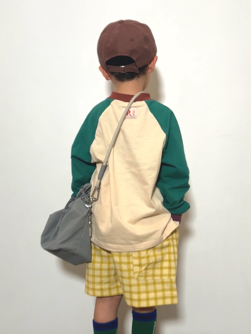 グリーン系のTシャツ/カットソー、イエロー系のその他パンツ、グレー系のショルダーバッグを着用したキッズの春コーディネートの4枚目の写真