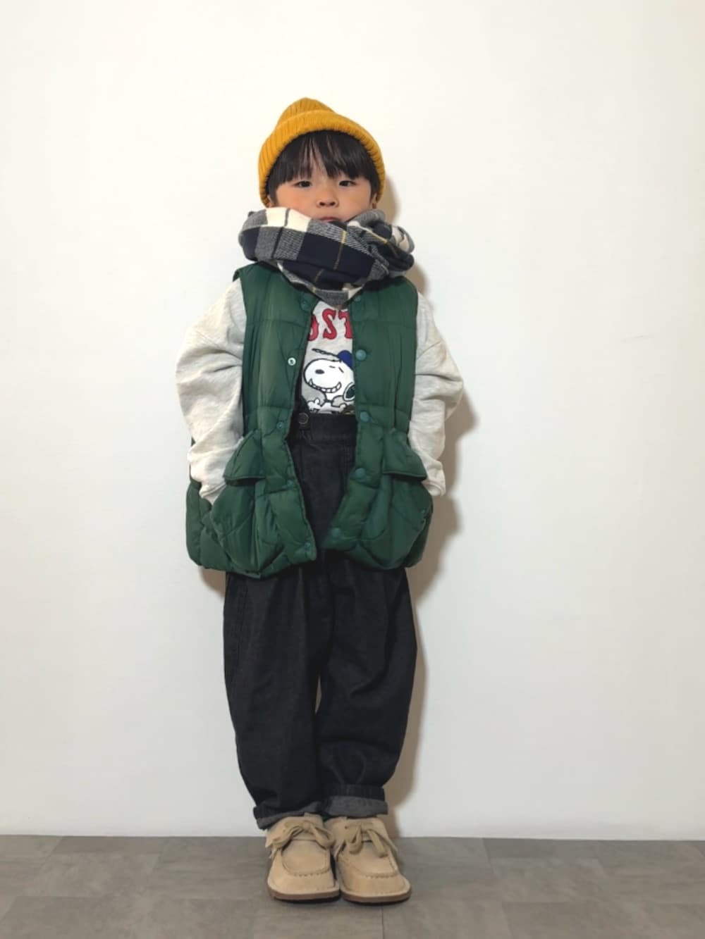 グレー系のスウェット、ブラック系のサロペット/オーバーオール、ベージュ系のモカシン/デッキシューズを着用したキッズの冬コーディネートの2枚目の写真