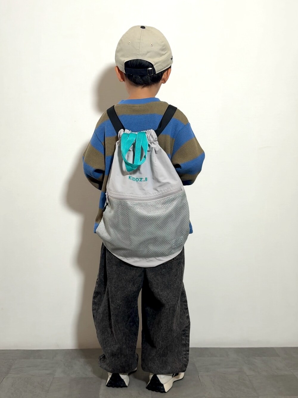 グレー系のバックパック/リュック、ブラック系のその他パンツ、ホワイト系のスニーカーを着用したキッズの秋コーディネートの3枚目の写真