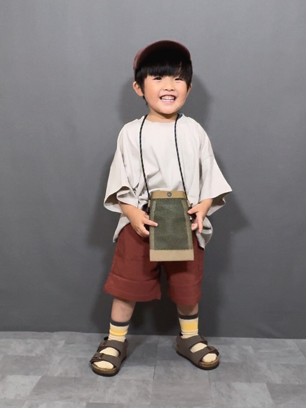 ベージュ系のTシャツ/カットソー、ブラウン系のその他パンツ、ベージュ系のショルダーバッグを着用したキッズの夏コーディネートの2枚目の写真