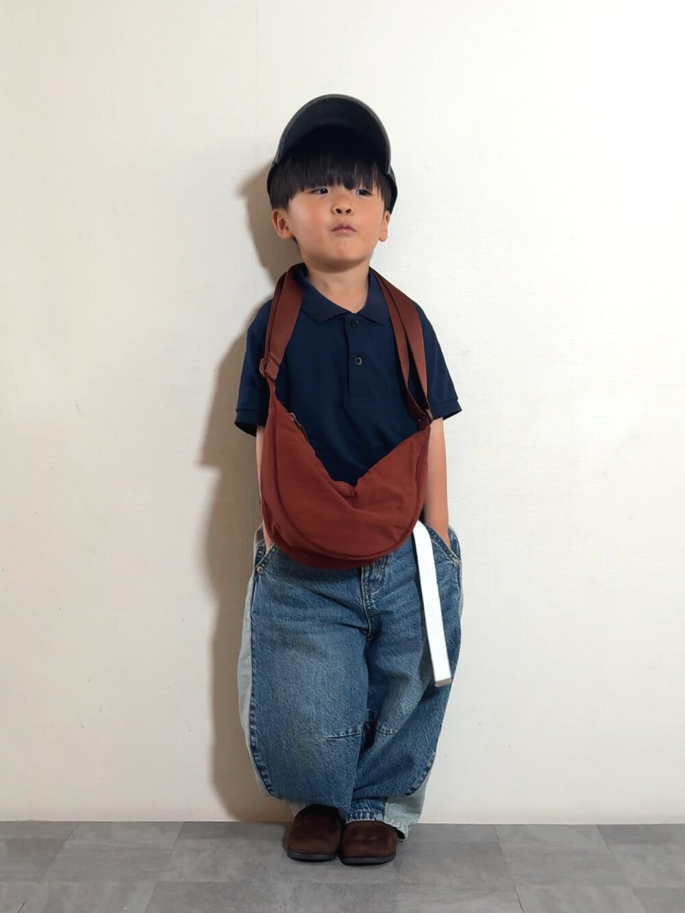 ブルー系のデニムパンツ、ブラウン系のブーツ、ブルー系のポロシャツを着用したキッズの夏コーディネートの3枚目の写真